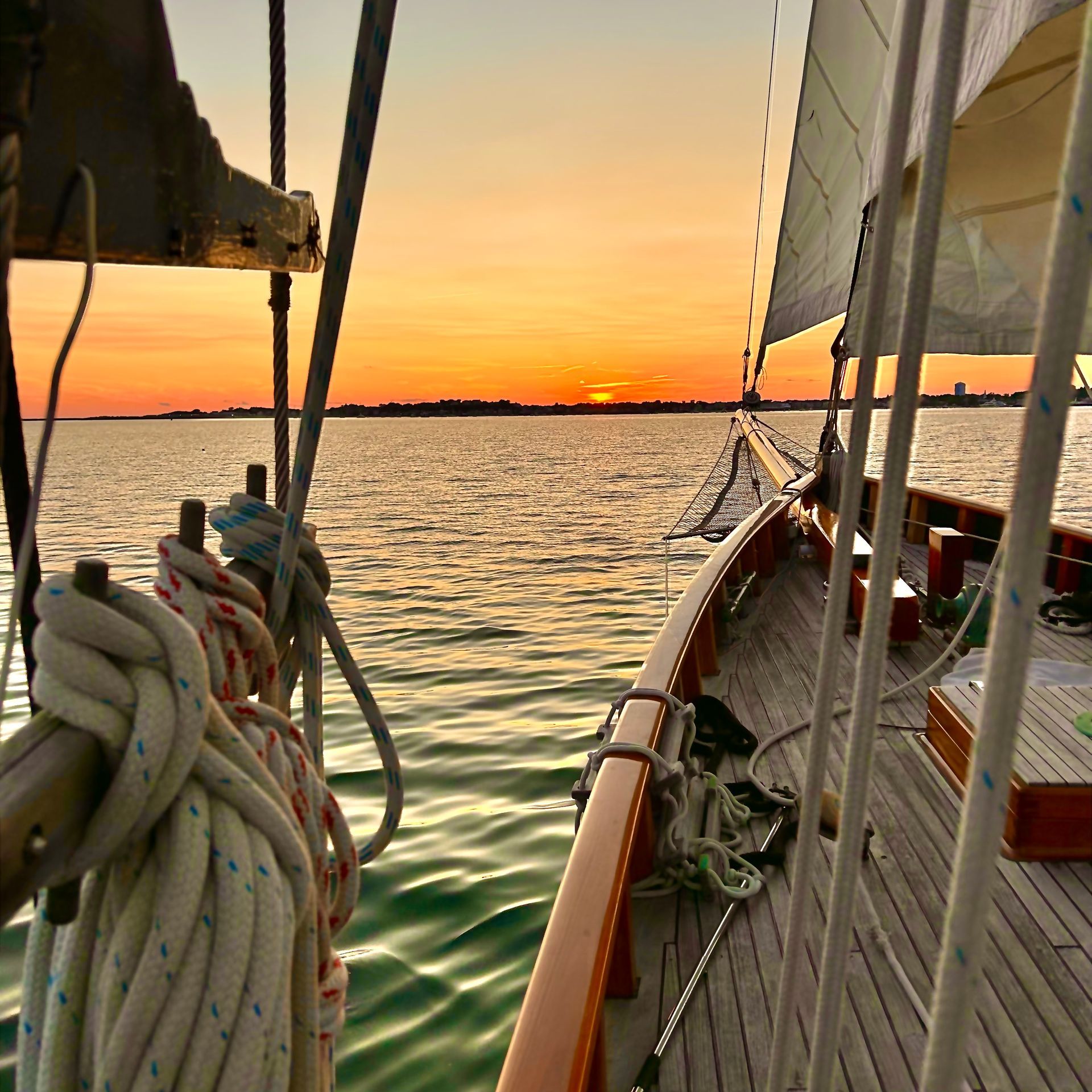 a sailboat is floating on the water at sunset