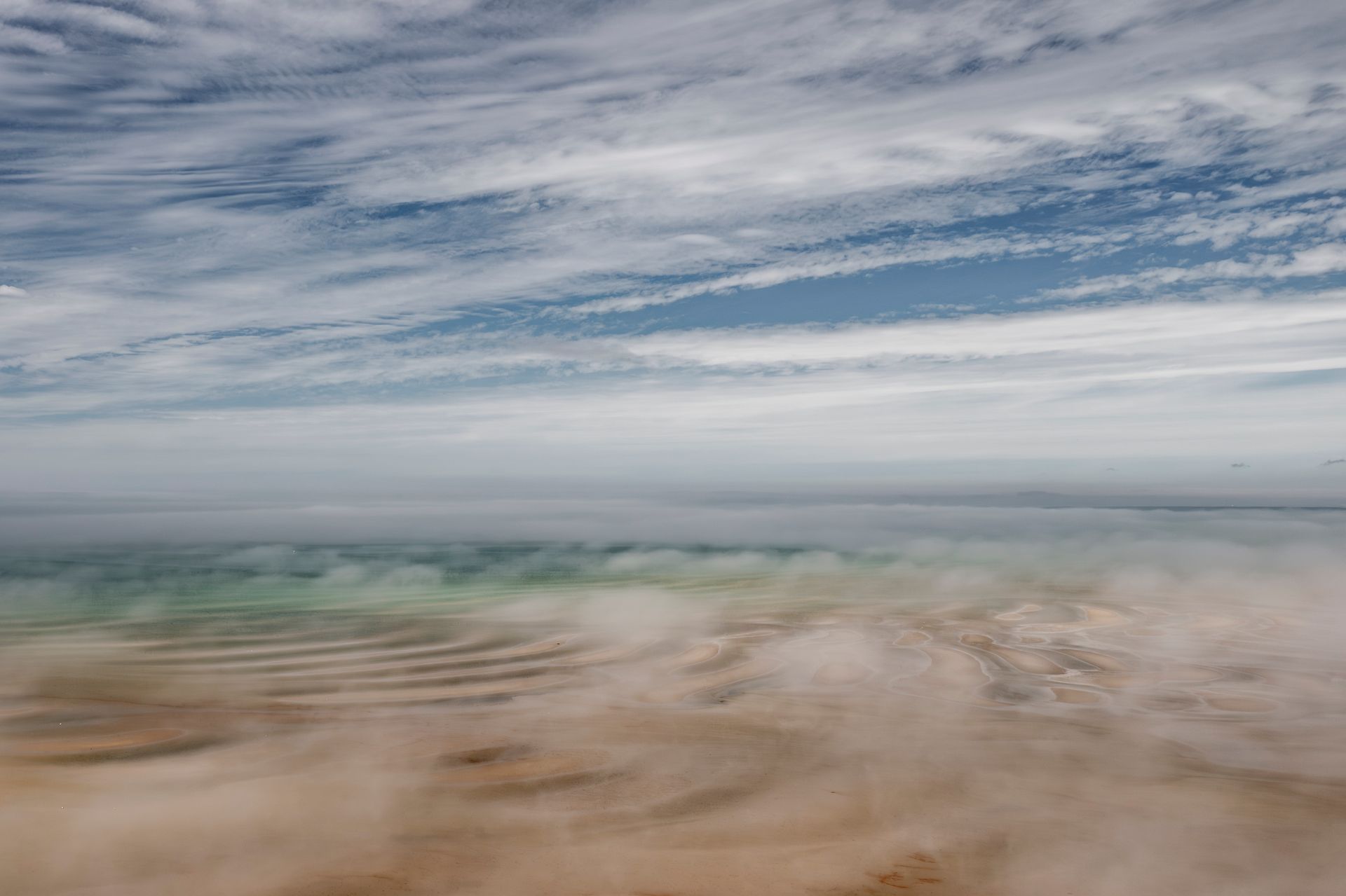 a blurry picture of a beach with a cloudy sky in the background .