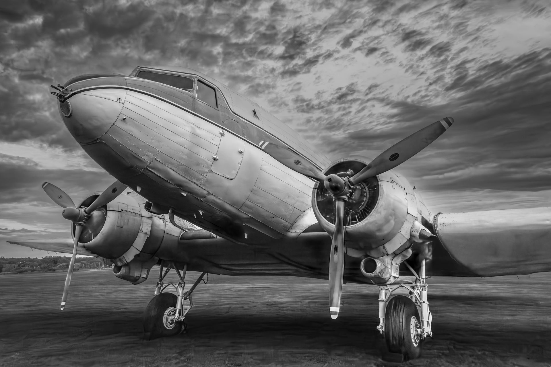 A black and white photo of an old propeller plane on a runway.