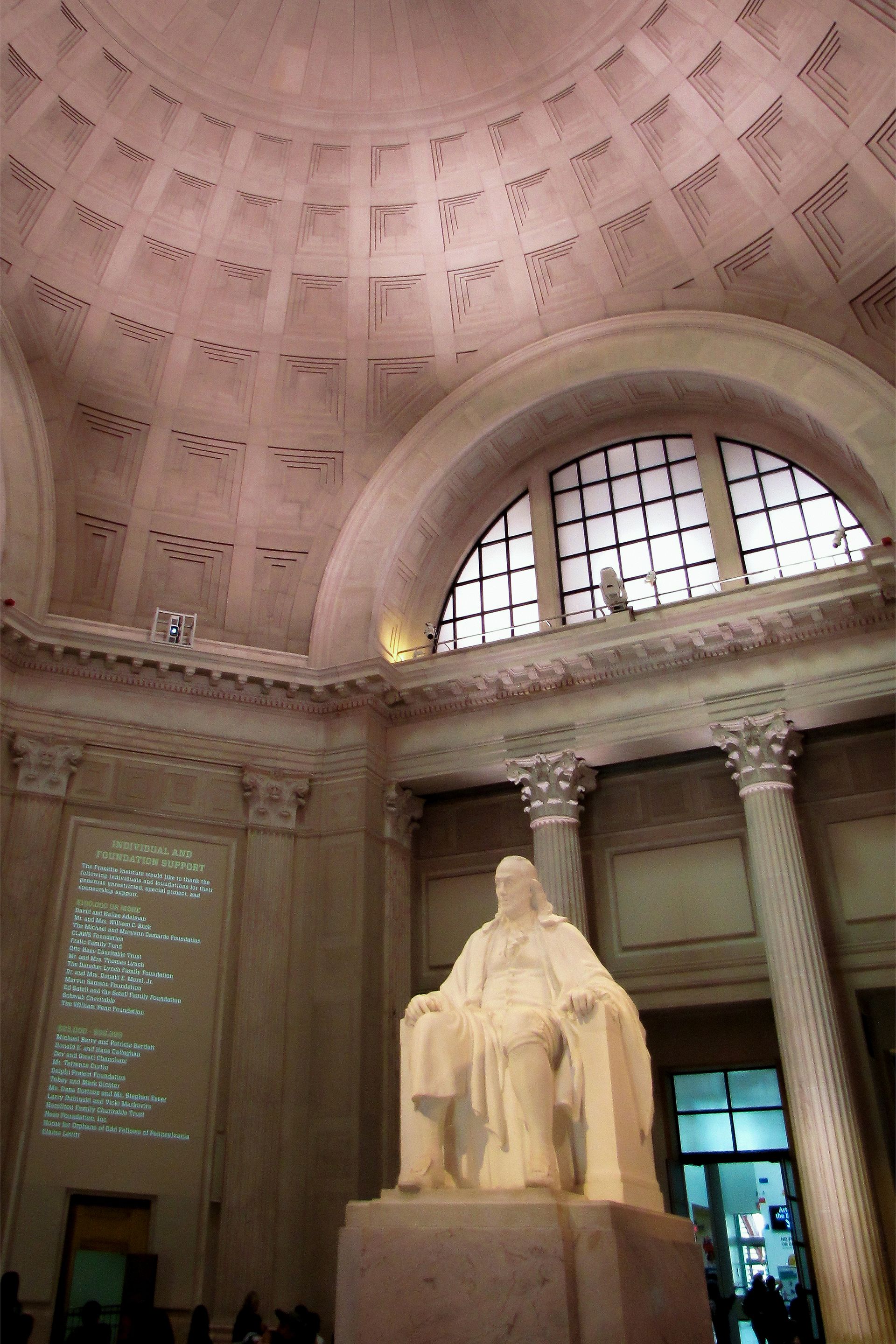 A man and a woman are posing for a picture in front of a white picket fence.