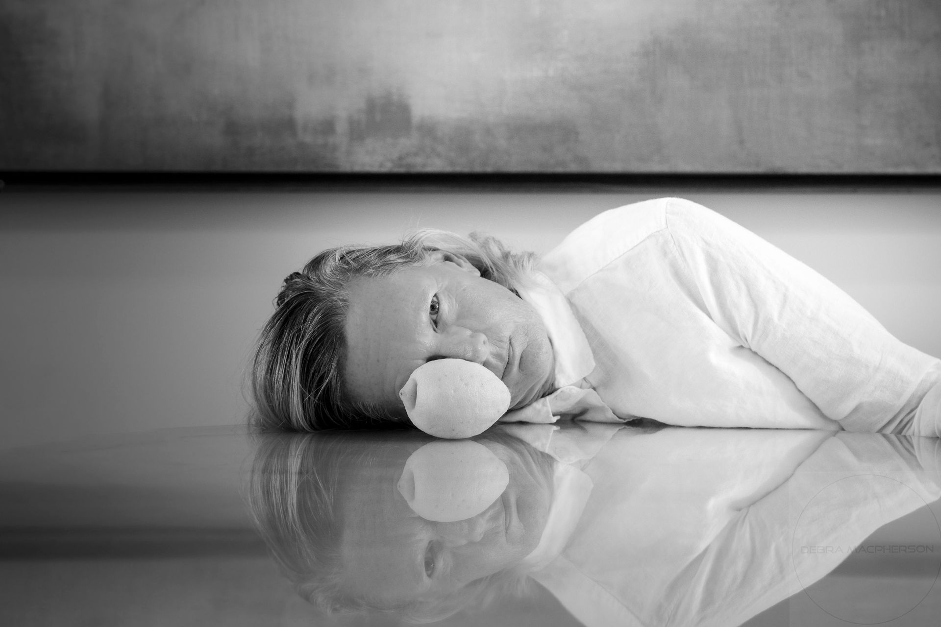 a black and white photo of a woman laying on the floor .
