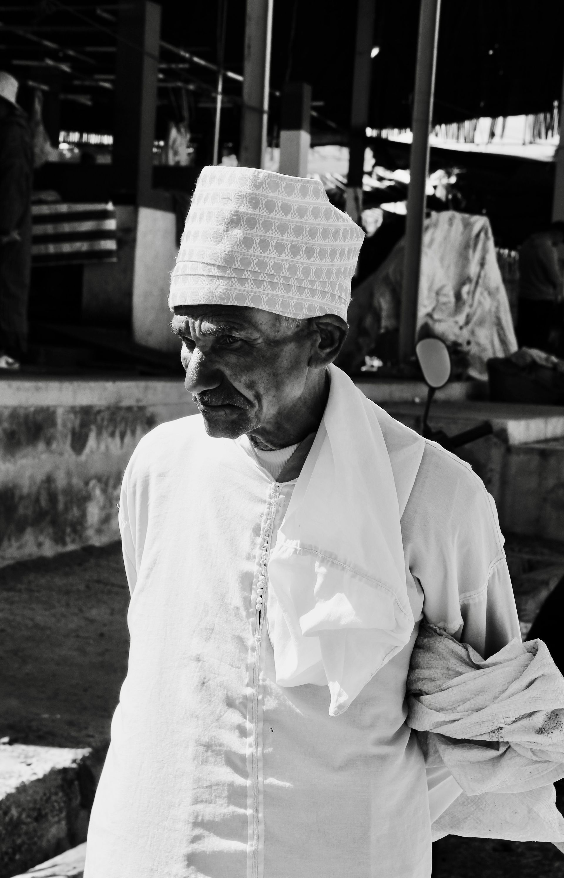 A black and white photo of a man wearing a white hat