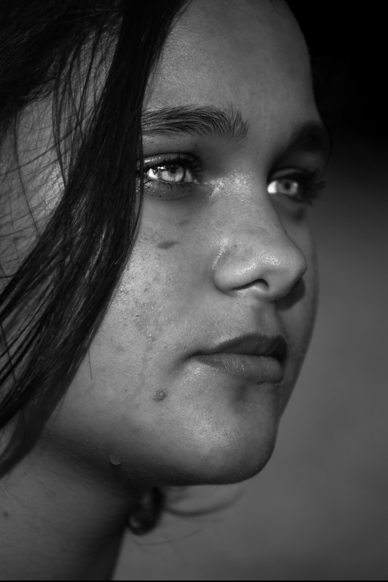 A close up of a woman 's face in a black and white photo.