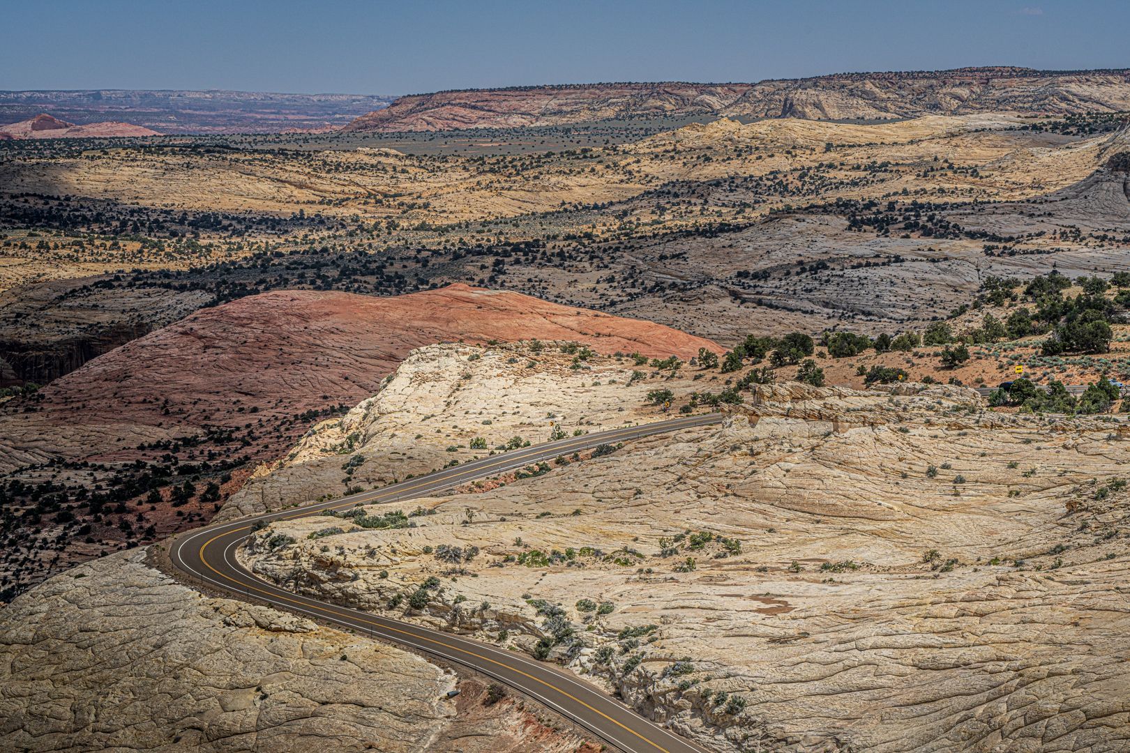 An aerial view of a road going through a desert landscape.