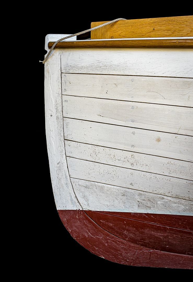 A close up of a white and red boat on a black background
