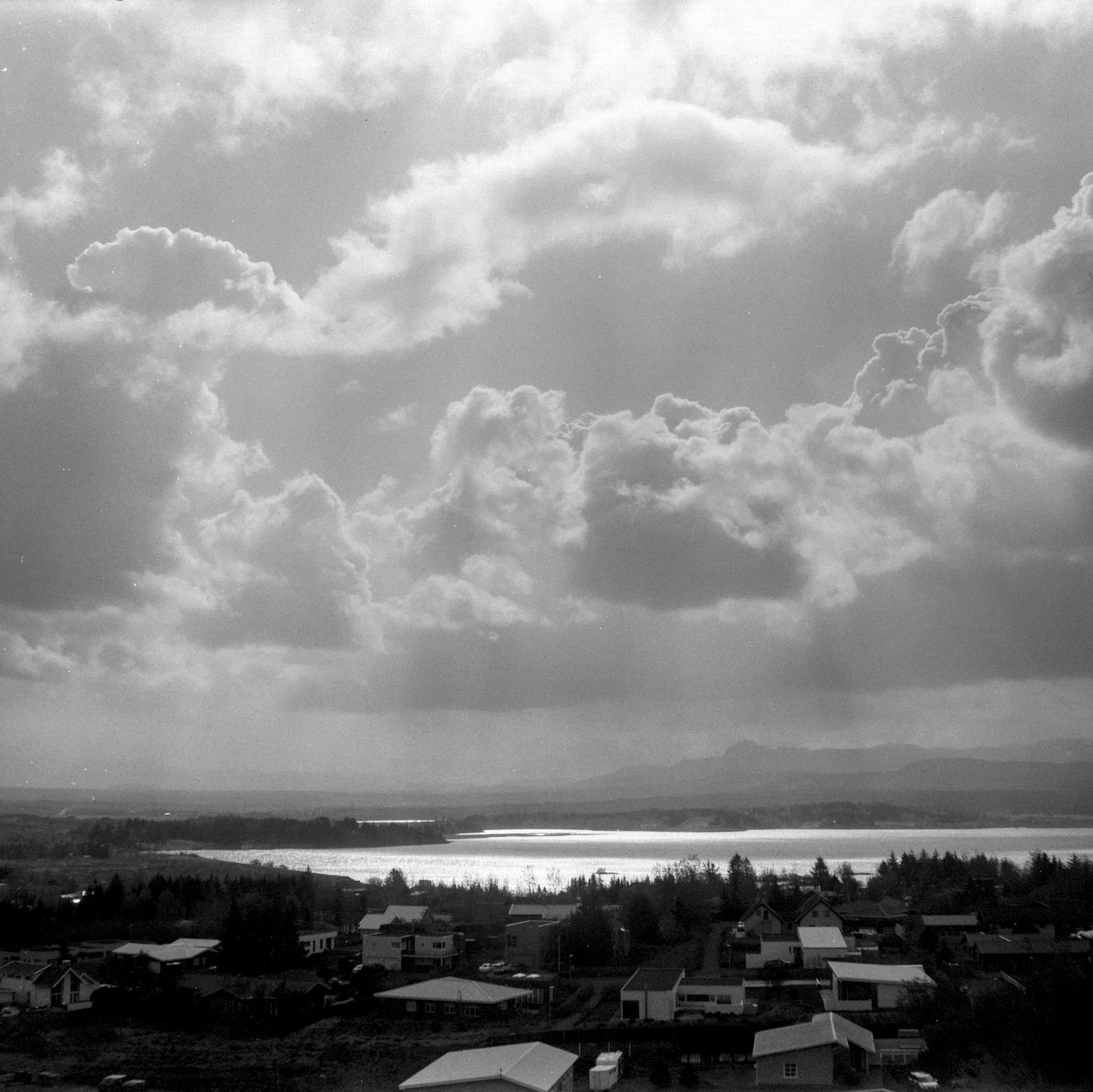 A black and white photo of a cloudy sky over a lake