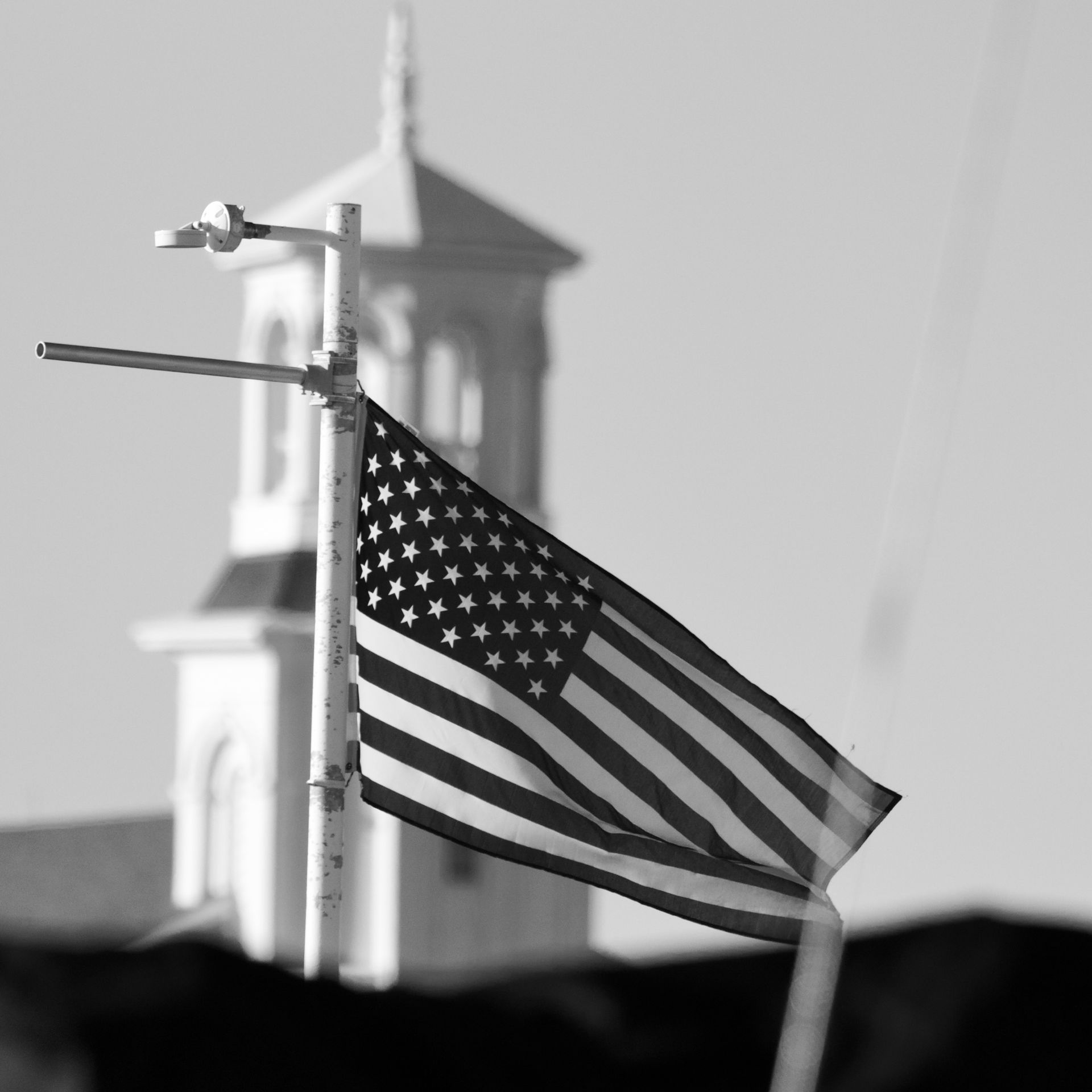 A black and white photo of an american flag on a pole