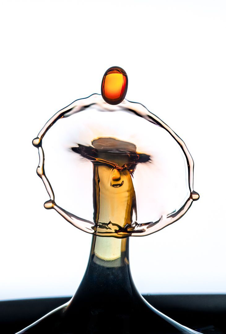 A close up of a bottle with a drop of liquid on top of it