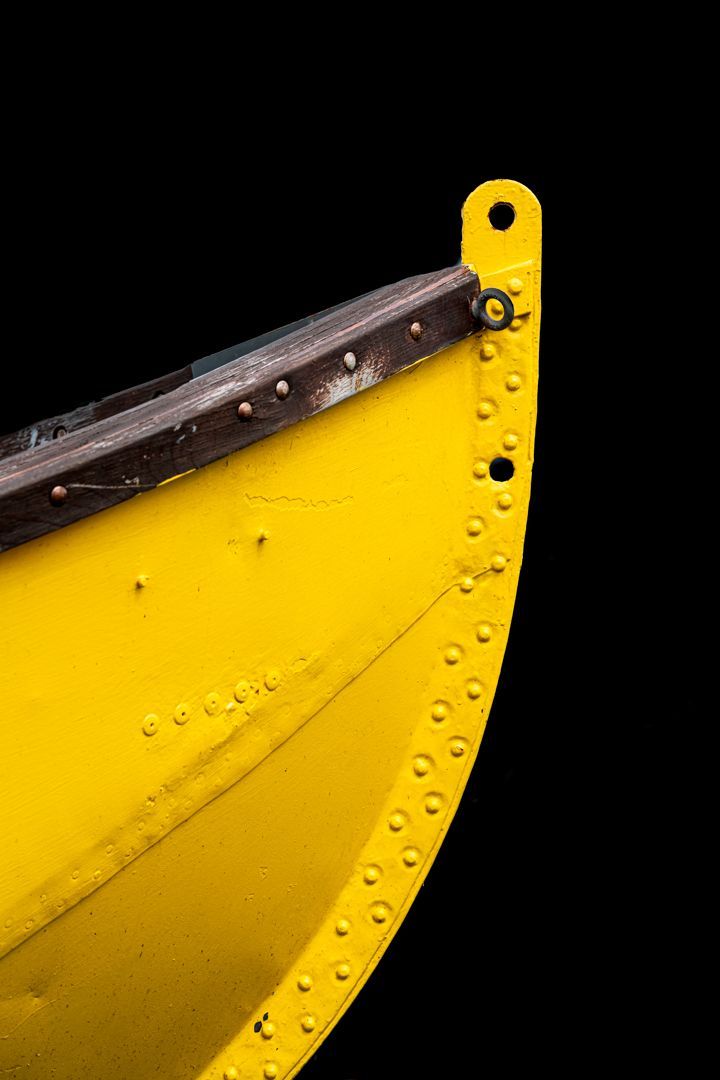 A close up of a yellow boat on a black background.