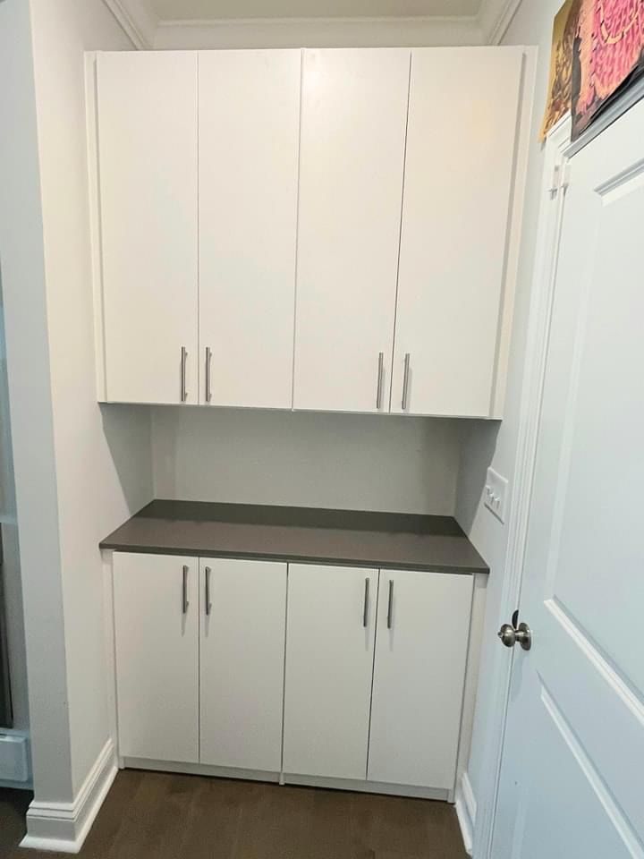 White cabinets with gray countertop in a hallway.