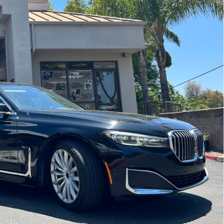 A black BMW luxury sedan parked in front of a building on a sunny day | Euro Auto Tech & Smog