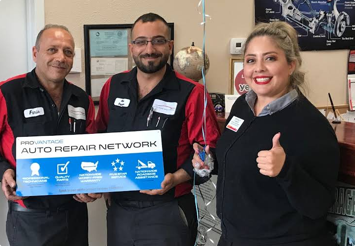 Three people in a shop hold a 