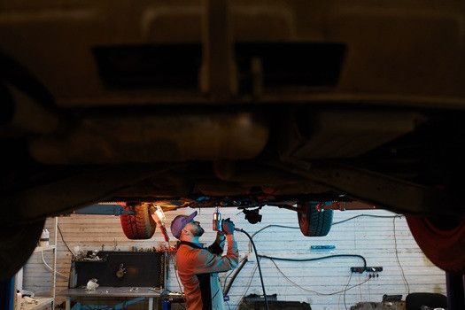 Technician working on underneath of vehicle | Euro Auto Tech & Smog Offers Oil Smog Inspection in San Diego County
