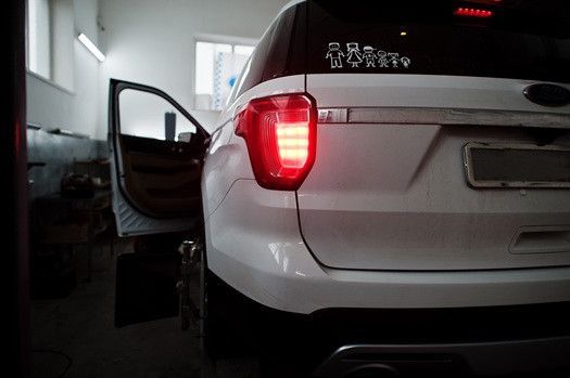 White van inside of garage, parked with brake lights on | Euro Auto Tech & Smog