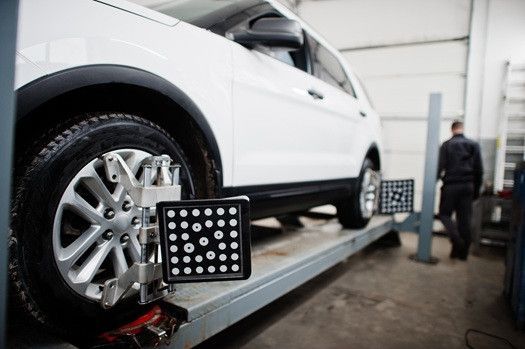 White van lifted up in garage to receive ADAS Calibration | Euro Auto Tech & Smog