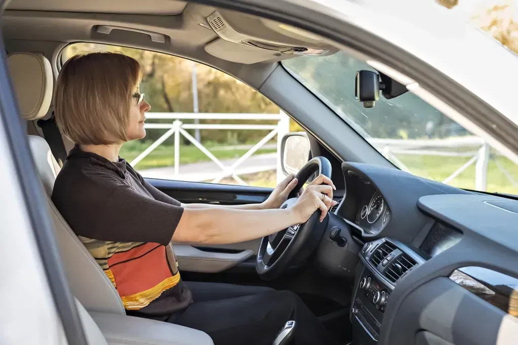 Woman sitting in car, driver's seat, focused on driving (AI-Generated) | Euro Auto Tech & Smog