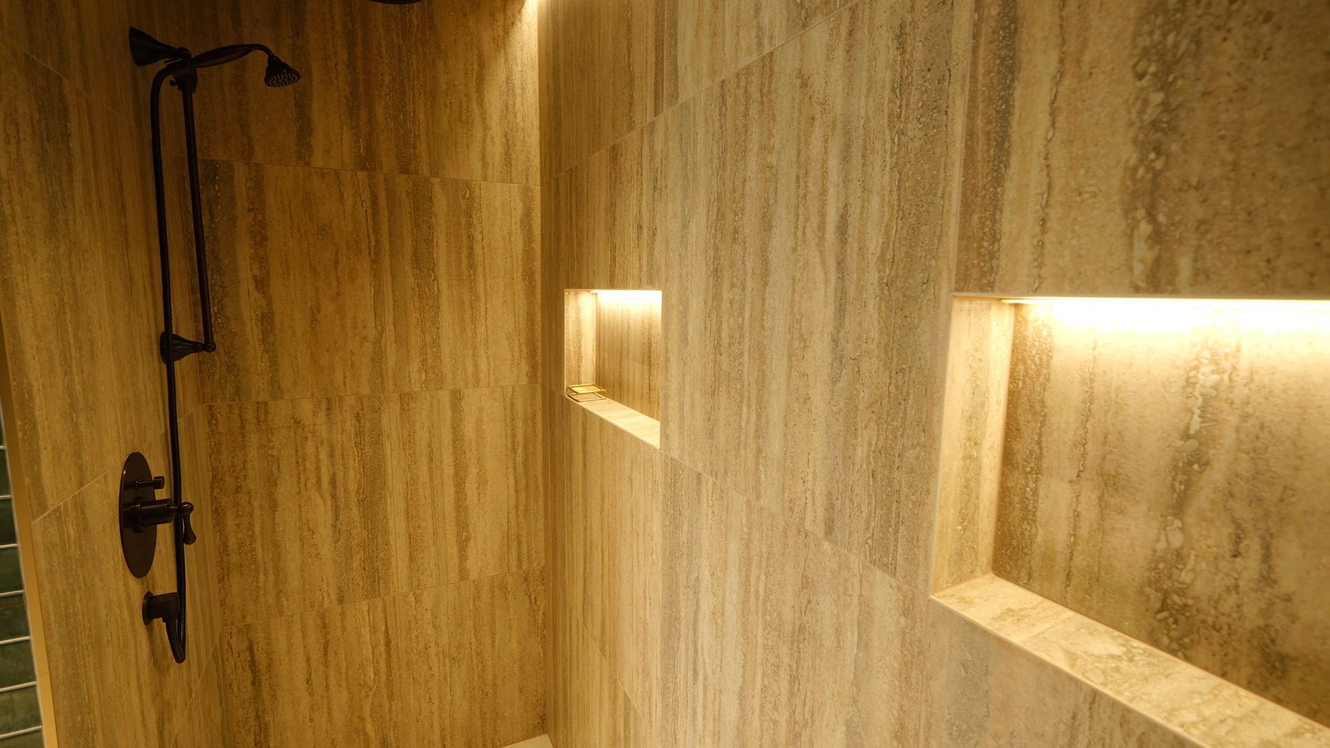 Une salle de bain avec douche et deux niches dans le mur.