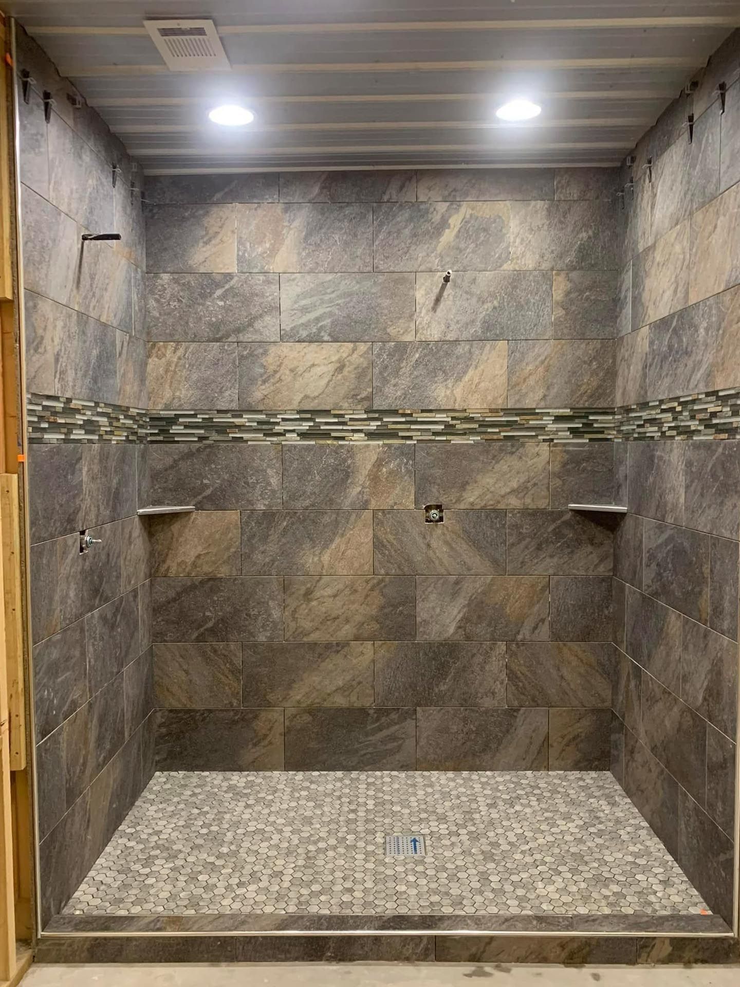 A bathroom with a walk in shower and tiled walls.