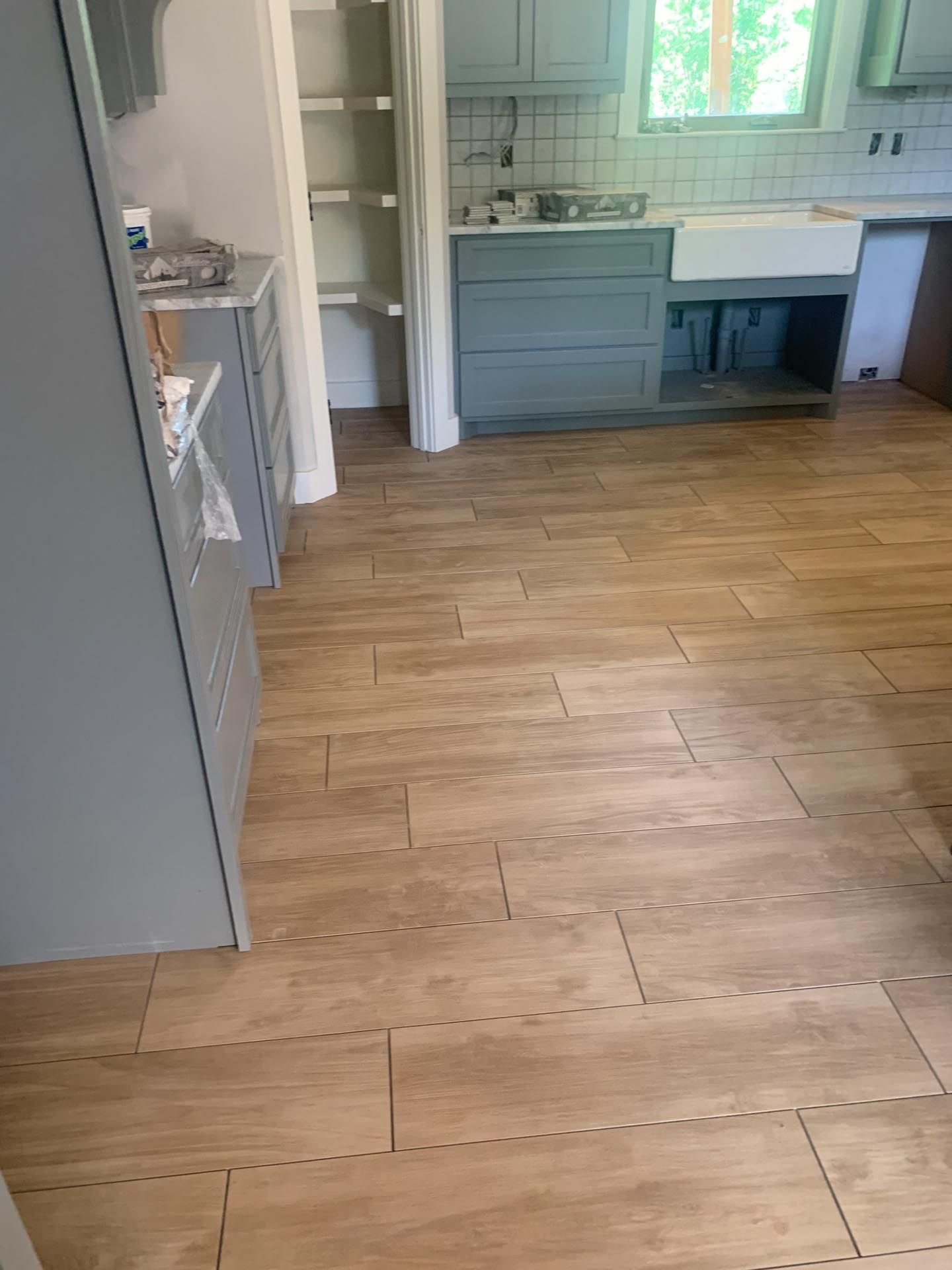 A kitchen with a wooden floor and a sink.