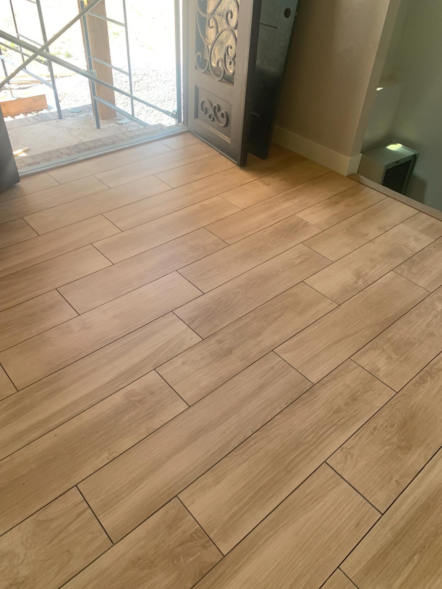 A wooden floor with a staircase in the background.