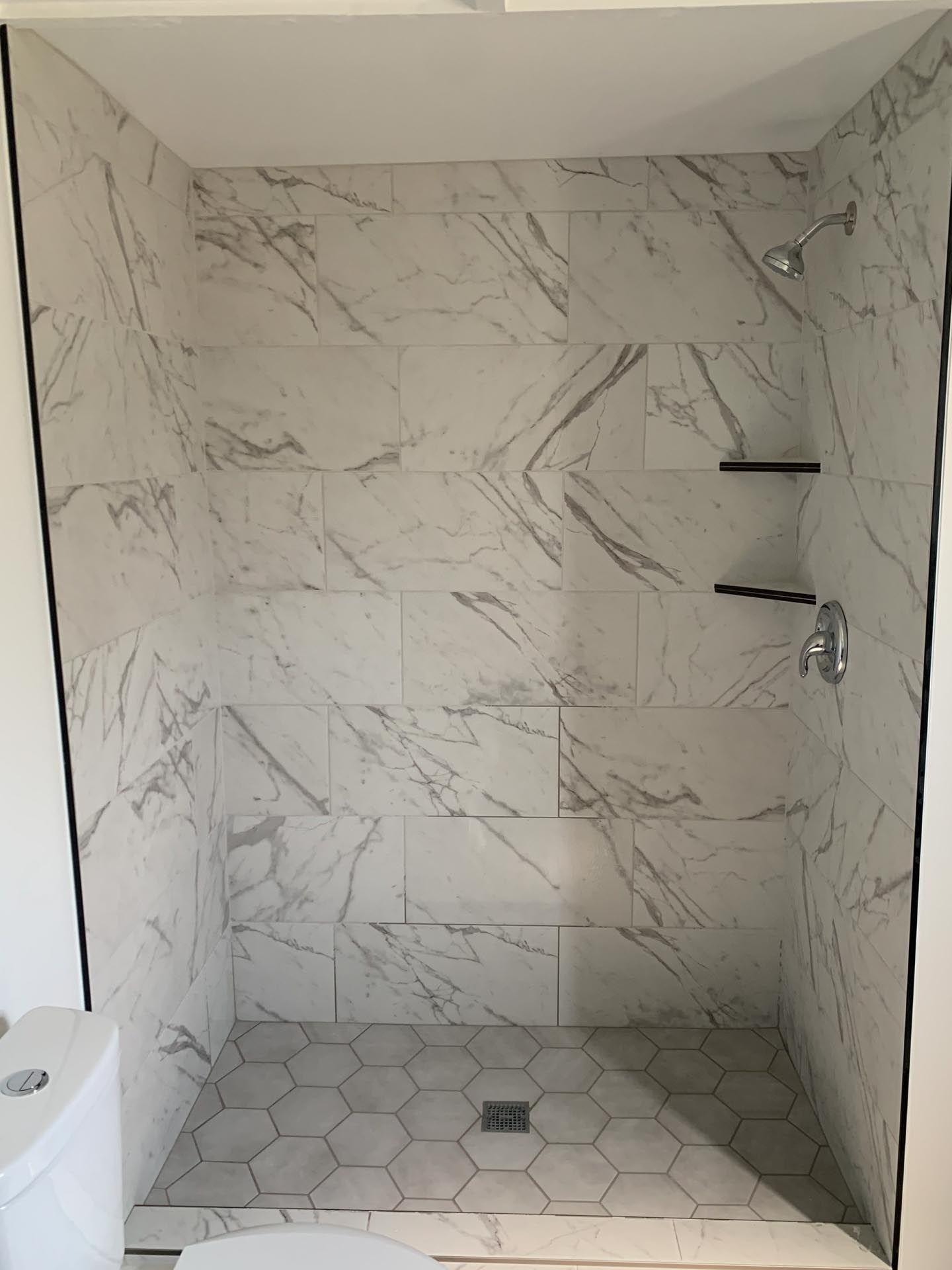 A bathroom with a walk in shower and a toilet.