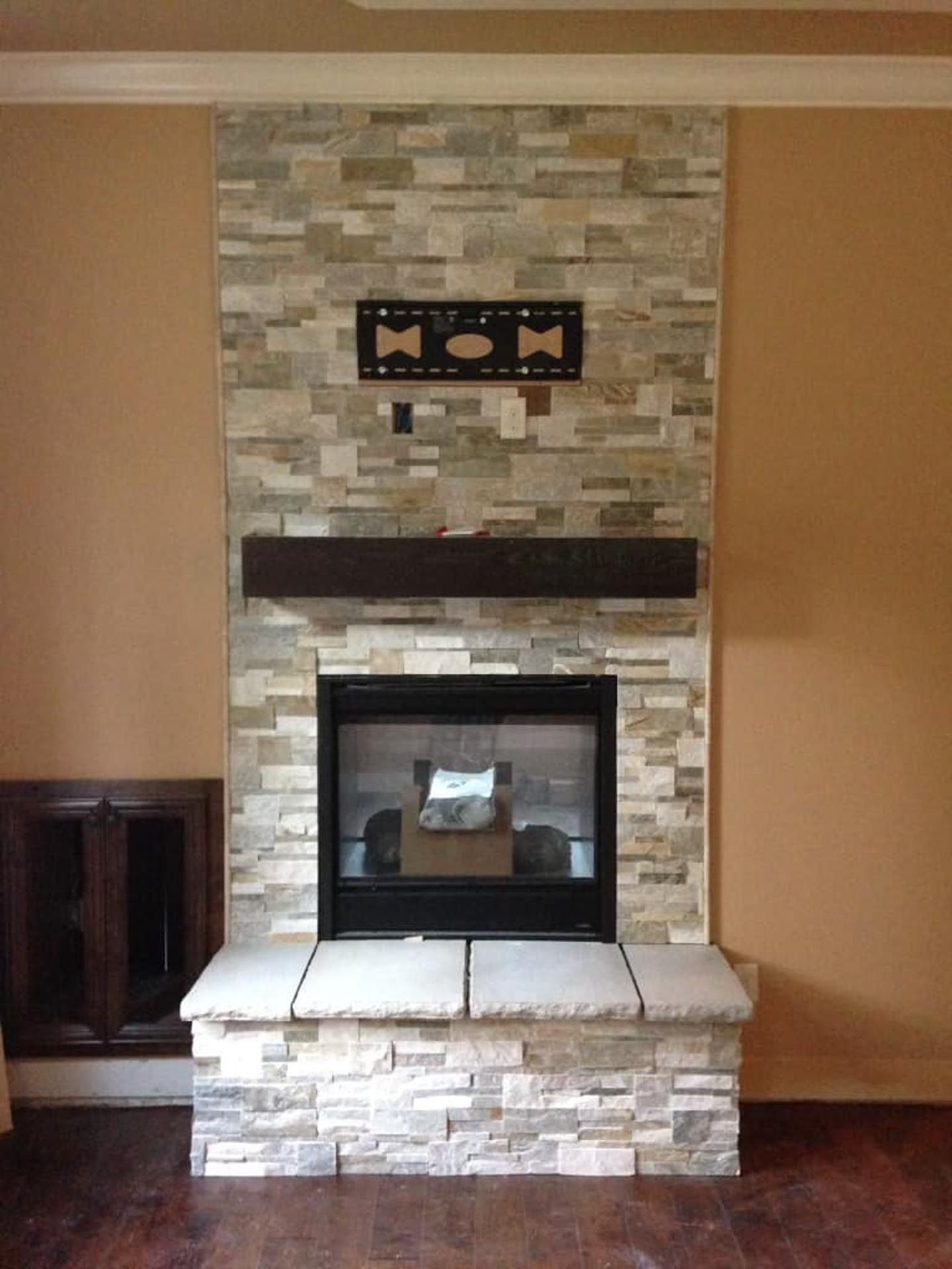 A stone fireplace with a flat screen tv mounted on the wall above it