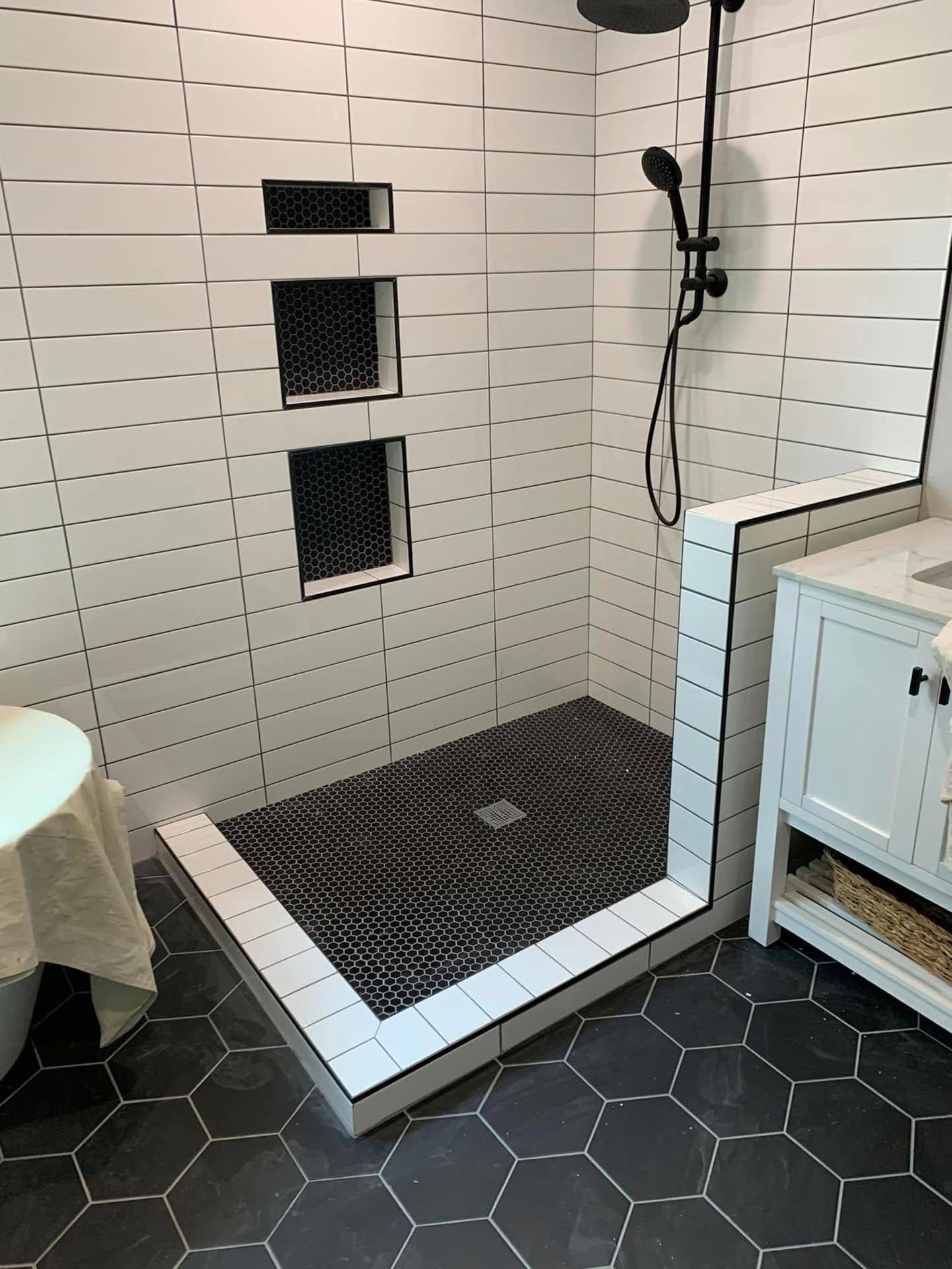 A bathroom with a walk in shower and a sink.