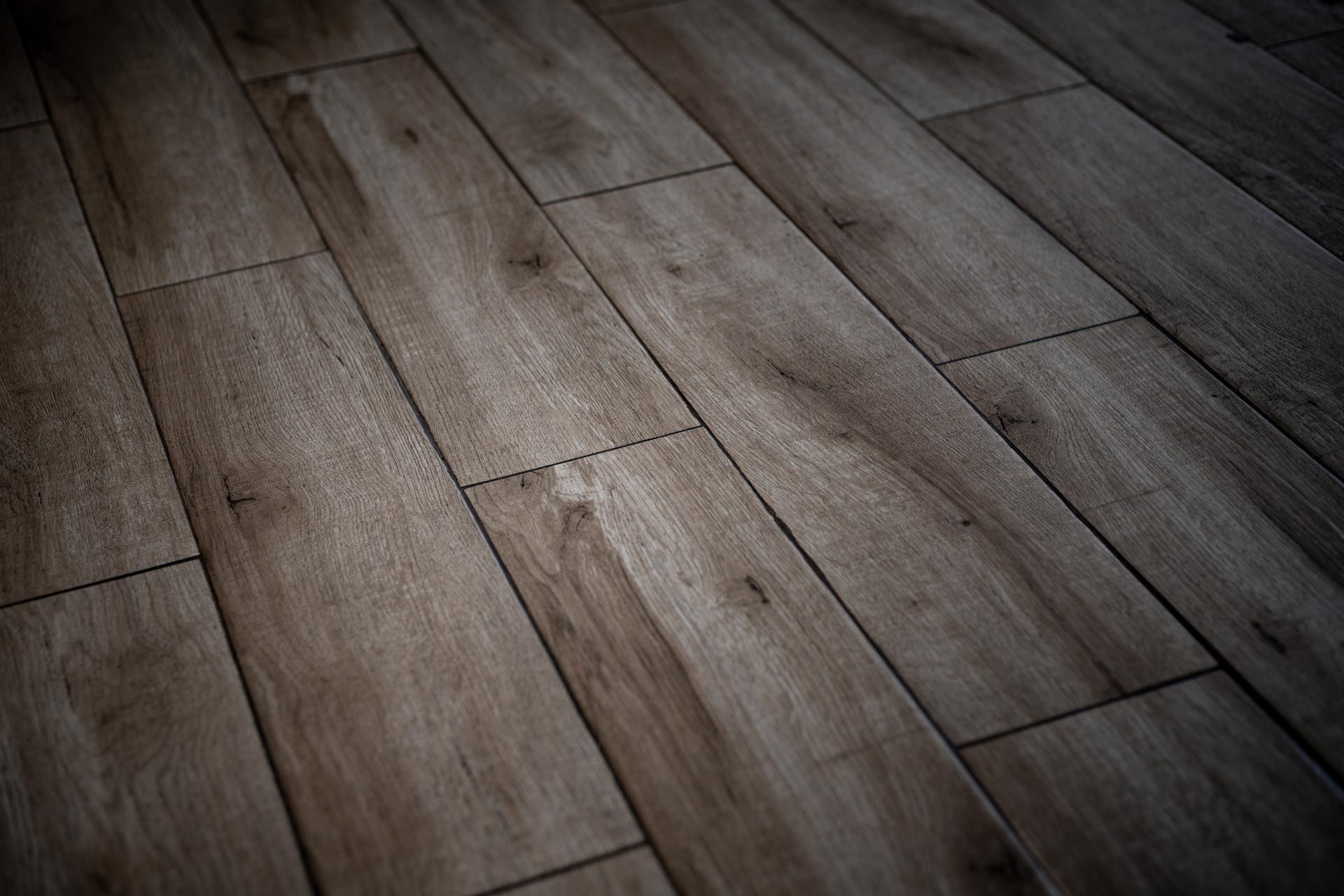 A close up of a wooden floor in a dark room.
