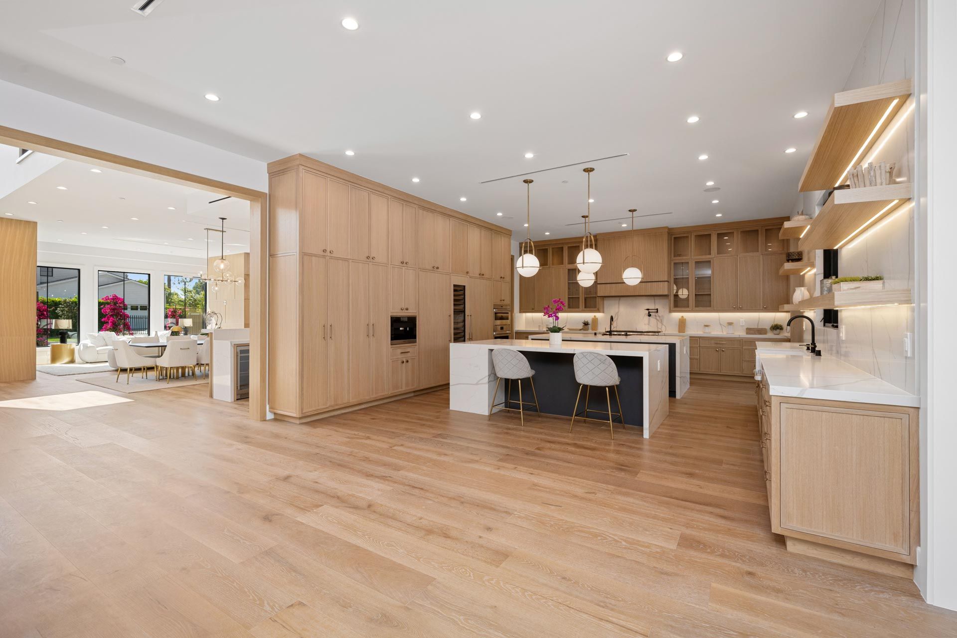 A large kitchen with wooden cabinets , white counter tops , and a large island.