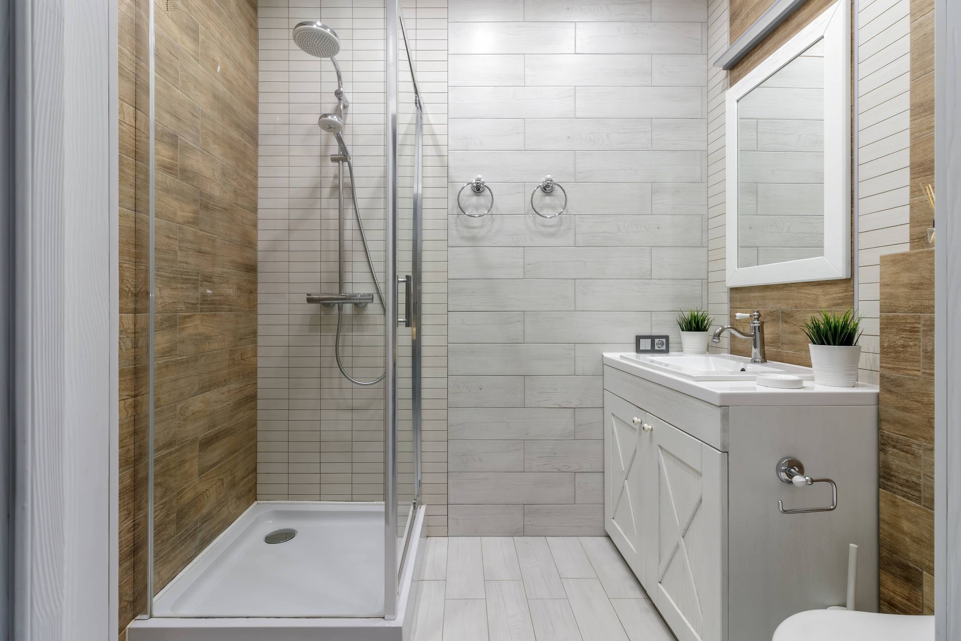 Modern bathroom with walk-in shower, white vanity, and tiled walls and floor