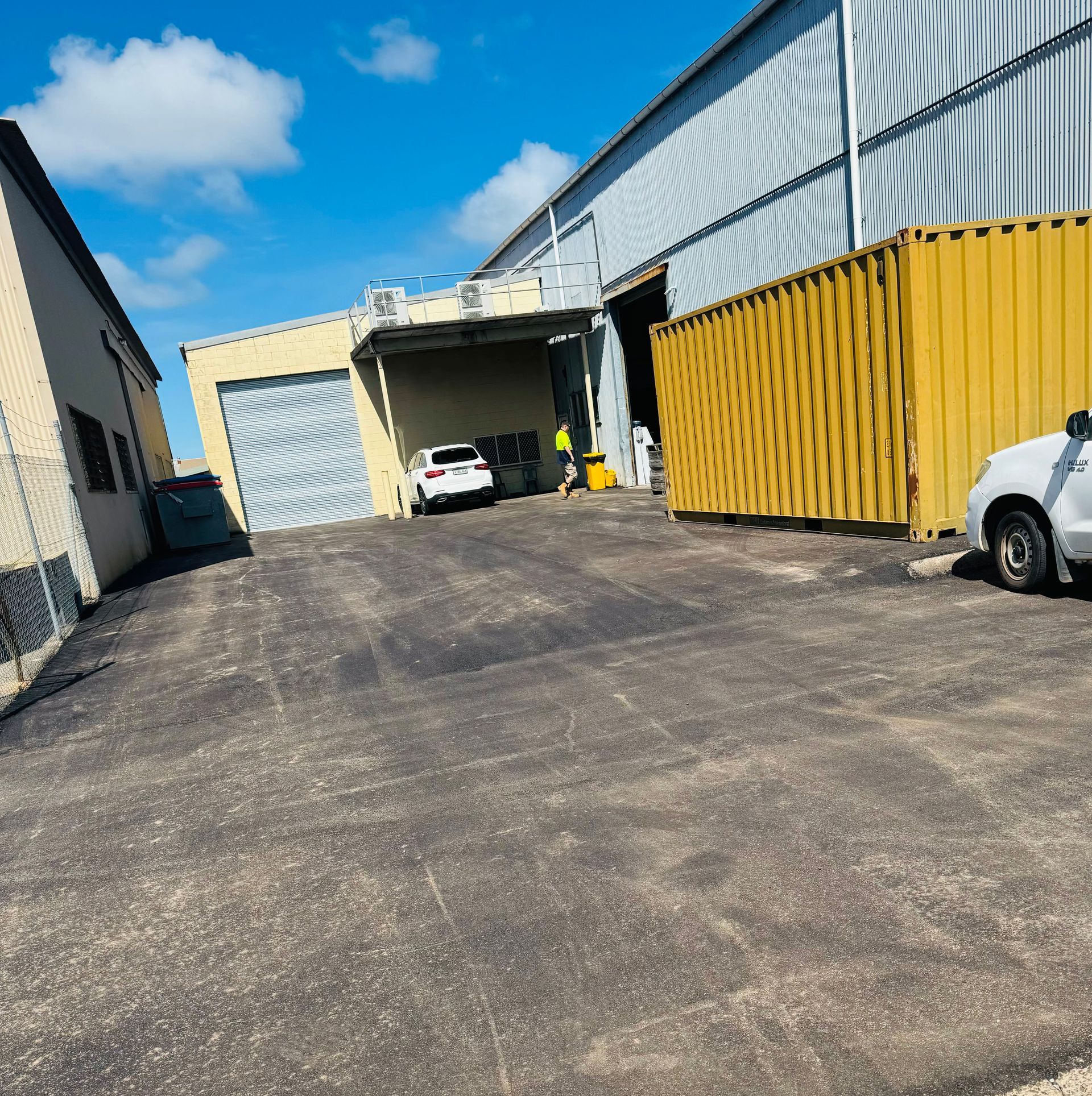 Fresh Asphalt on a trail  with Yellow Shipping Containers — Appian Roads In Urangan, QLD