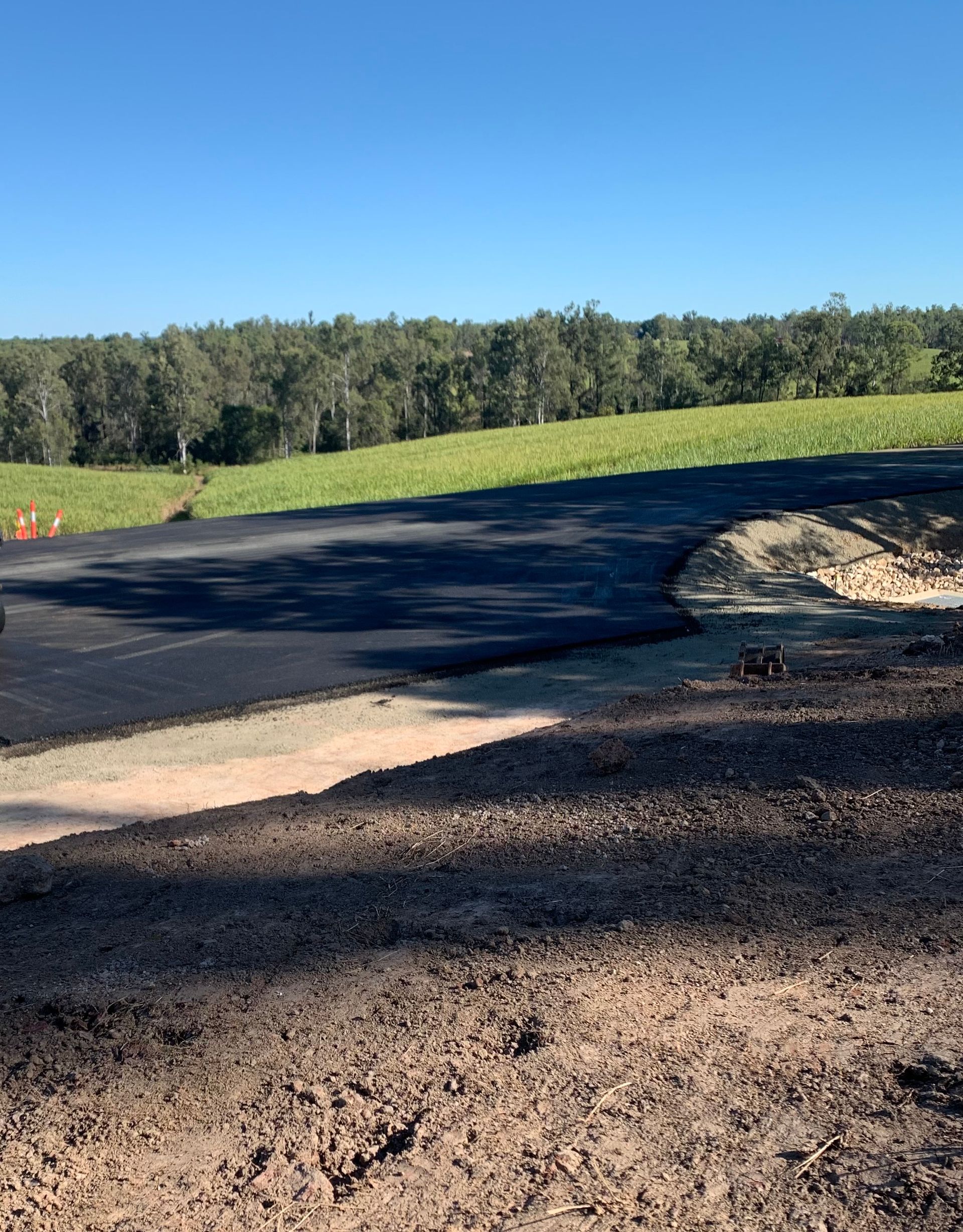 A Road Is Being Paved With A Roller And A Spreader — Appian Roads In Urangan, QLD