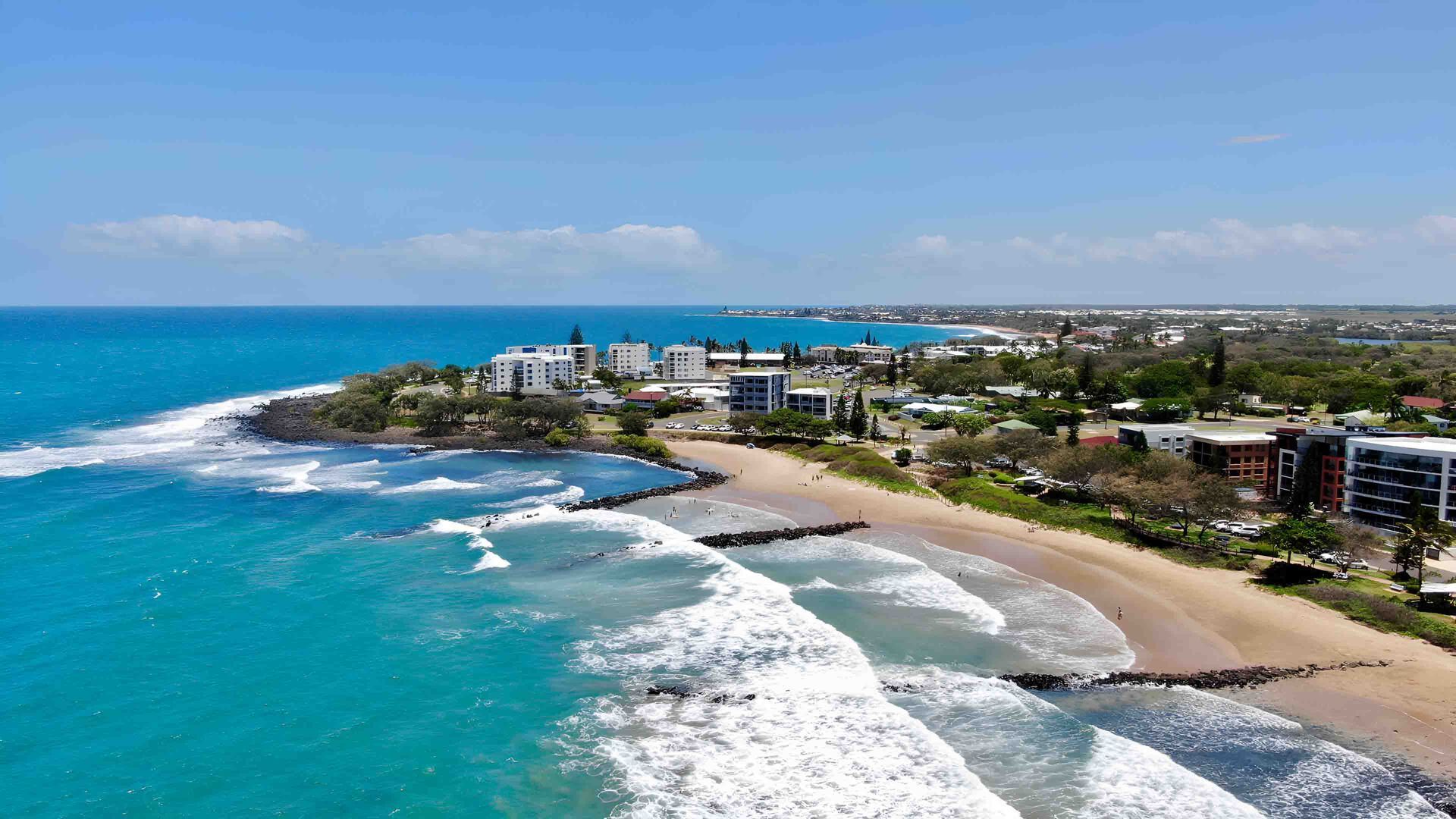 An Aerial View Of A Beach With Waves Crashing On The Shore — Appian Roads In Bundaberg, QLD