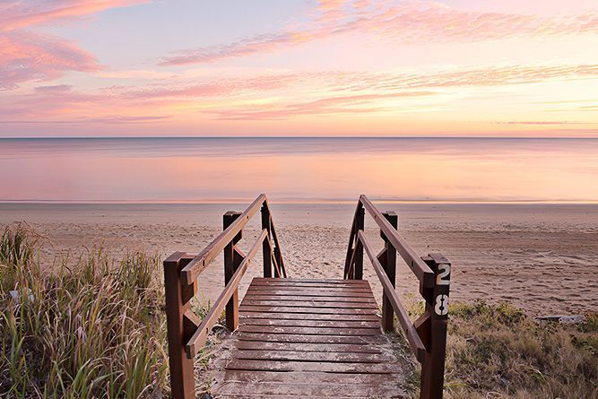 A Wooden Walkway Leading To The Ocean At Sunset — Appian Roads In Herbey Bay, QLD