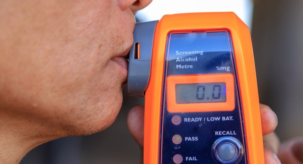 Man Taking Breath Test — Cairns Traffic Lawyers  in Cairns, QLD