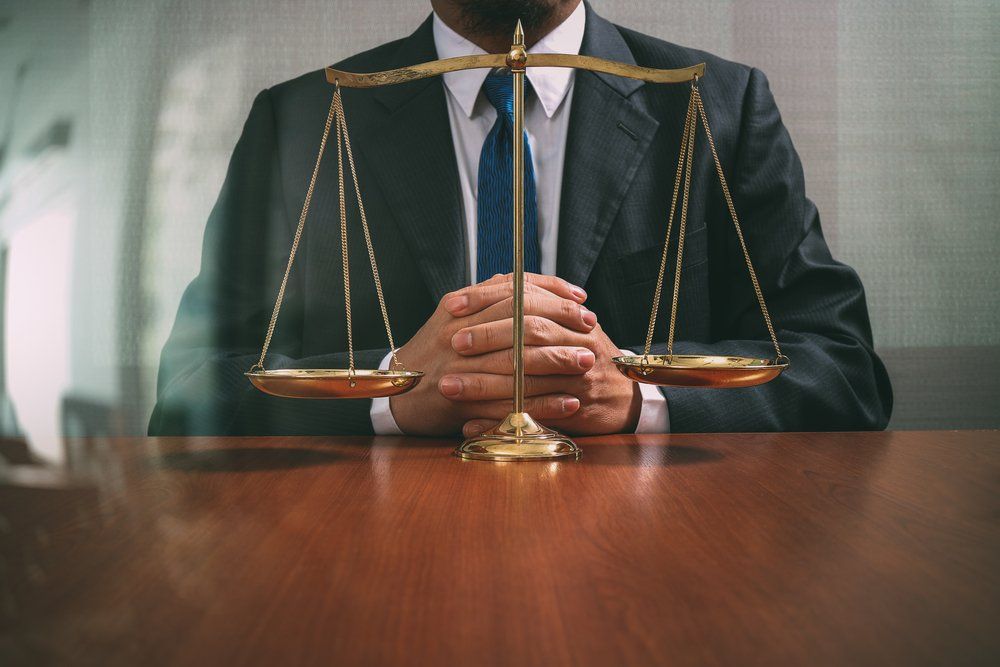 Lawyer Sitting Behind Justice Scales — Cairns Traffic Lawyers  in Cairns, QLD