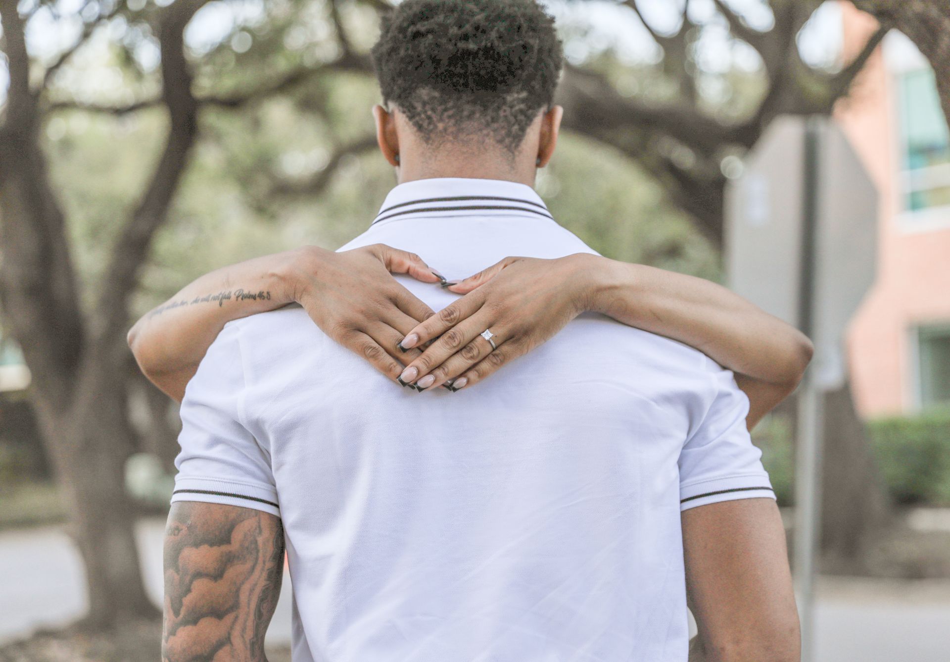 Woman in white dress posing by a Piazza San Marco sign, with patterned building in background.