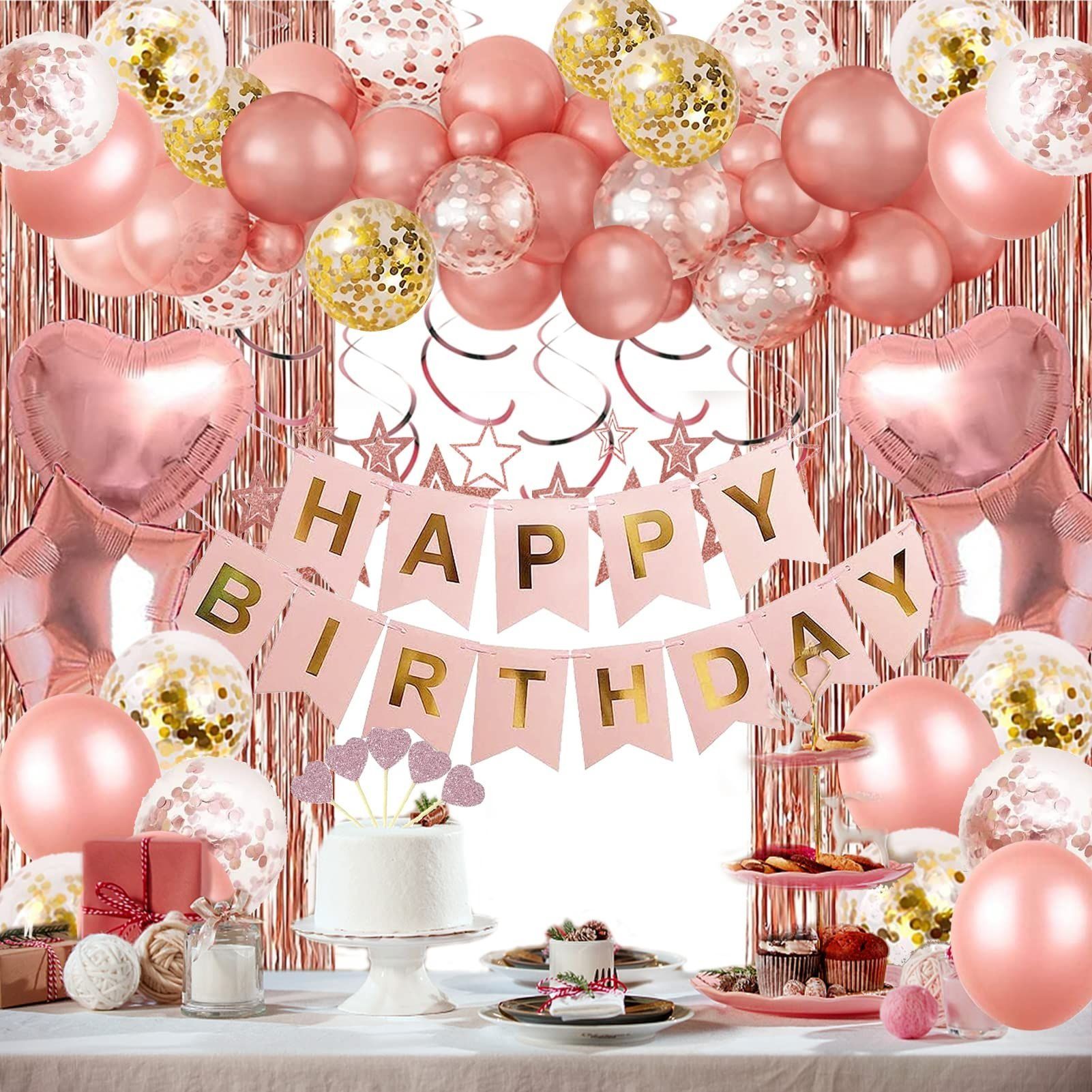 Birthday party decorations: pink balloons, heart-shaped foil balloons, banner, cake, and food on a table.