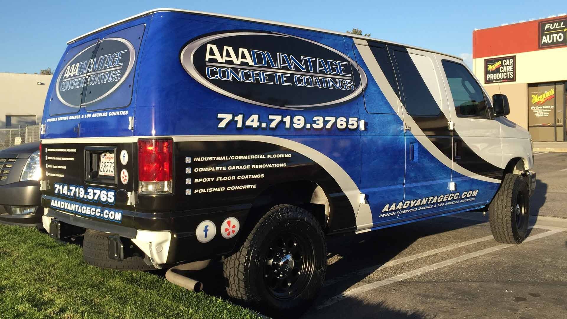 A blue and black custom van parked outdoors with large AAA Concrete text and a phone number displayed on its side.
