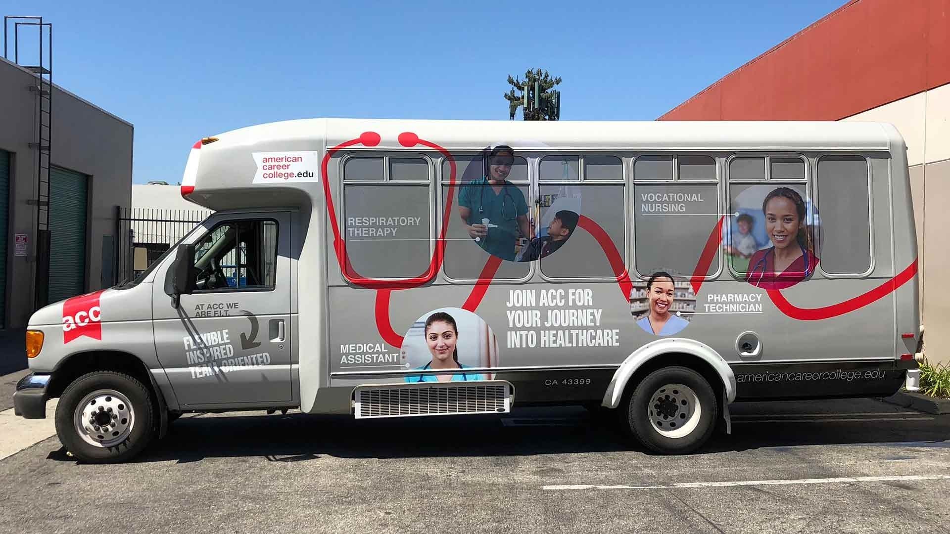 A silver shuttle bus featuring medical-themed graphics, a red stethoscope design, and photographs of healthcare workers.