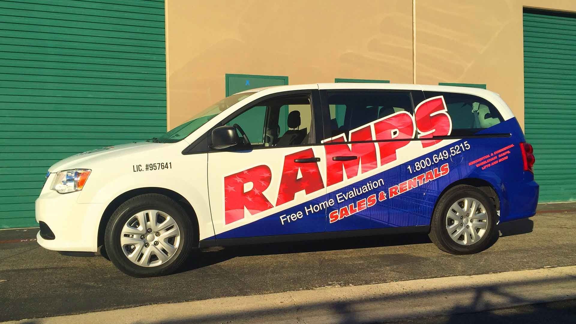 White minivan parked in front of a green garage door, displaying 