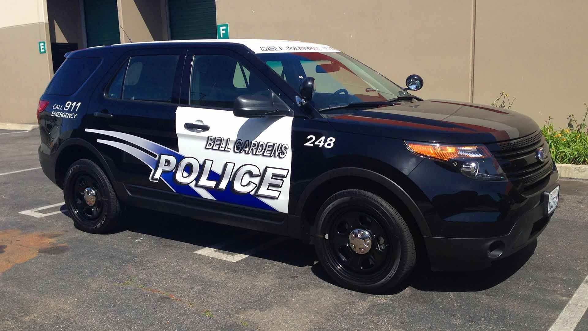 A black police SUV parked in a lot, featuring the text 