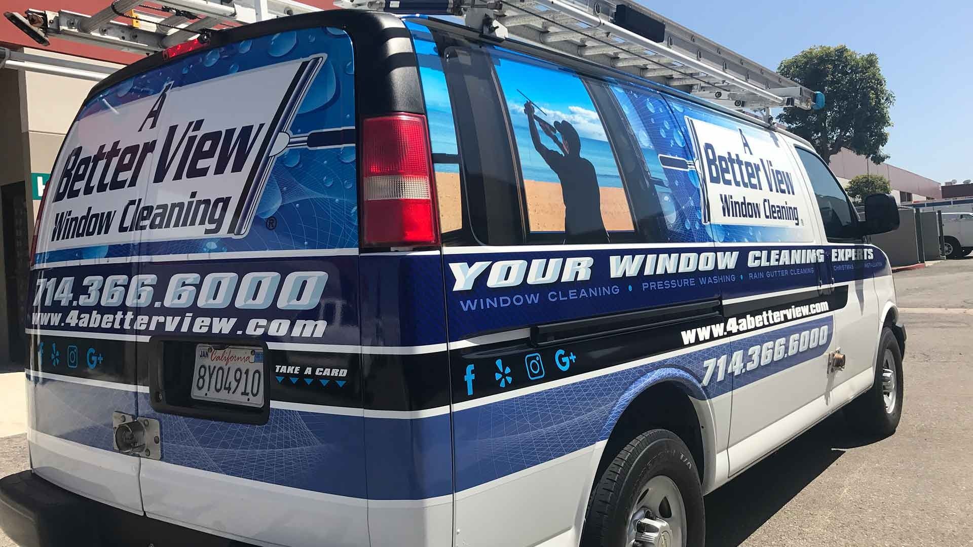 A blue and white van for A Better View Window Cleaning, featuring the company logo, website, and phone number.