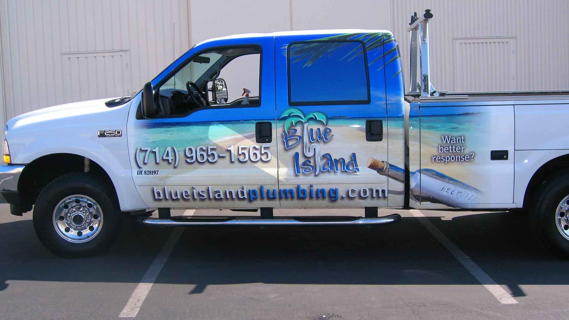 Blue Island Plumbing truck with blue and white tropical ocean branding, including phone number and website.