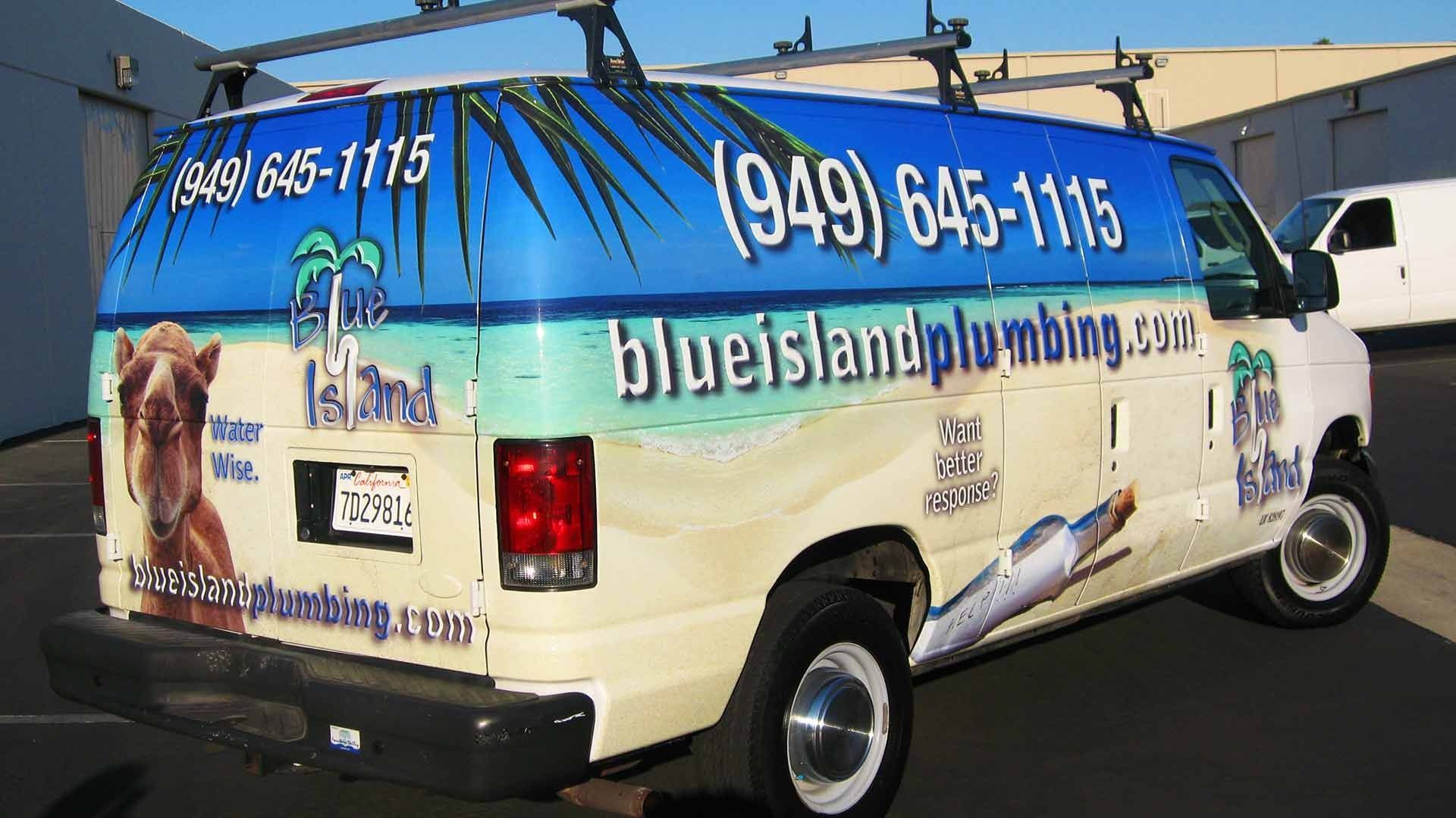 Blue Island Plumbing van with a beach-themed wrap, a camel image, and contact information, parked on an asphalt lot.