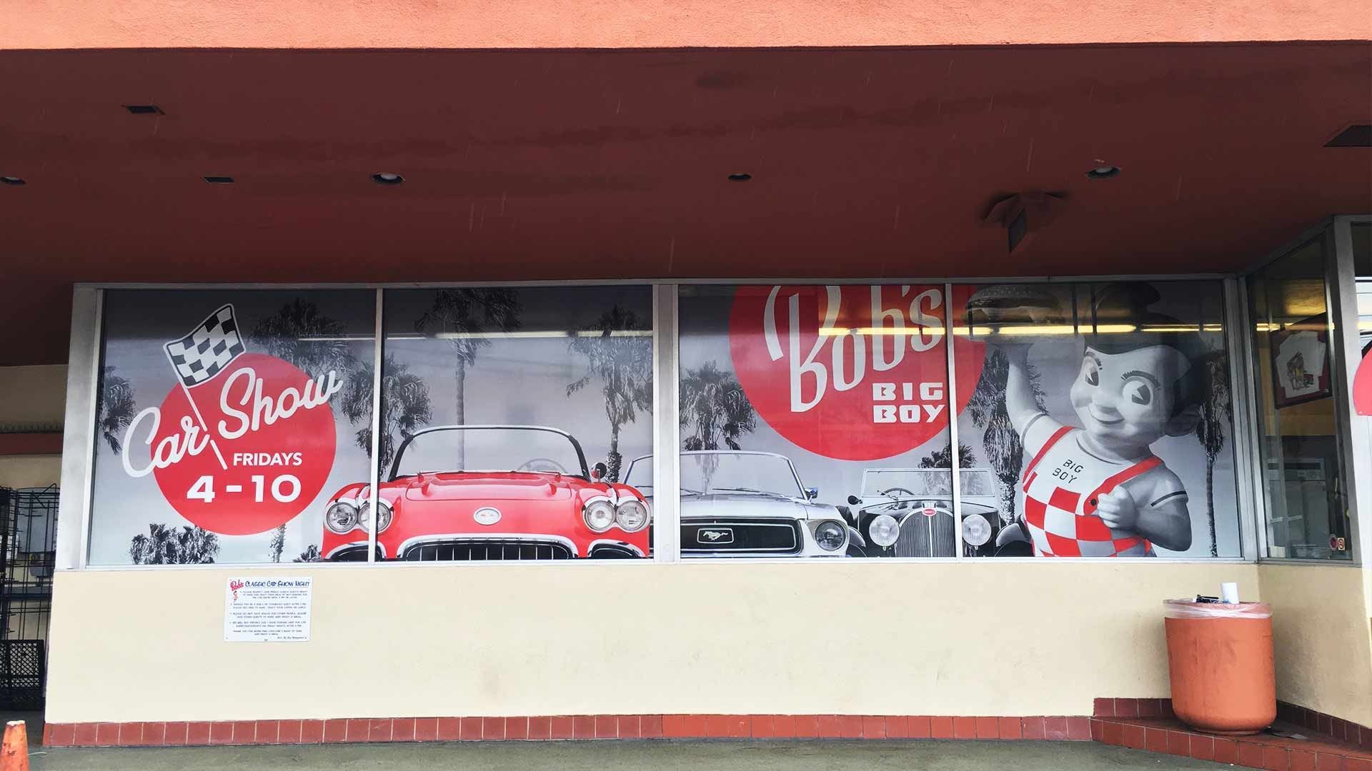 The exterior of a Bob's Big Boy restaurant featuring window decals for a car show from 4-10.