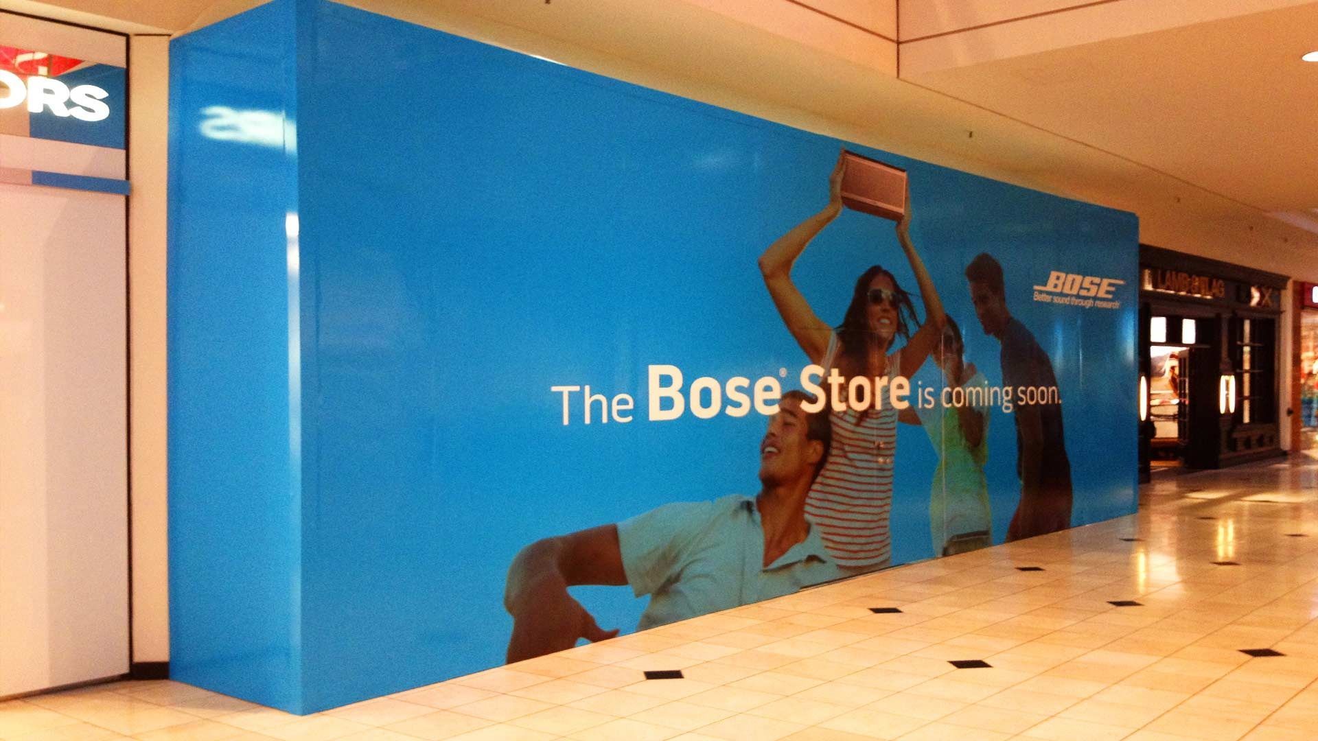 A blue construction barricade in a shopping mall announces 
