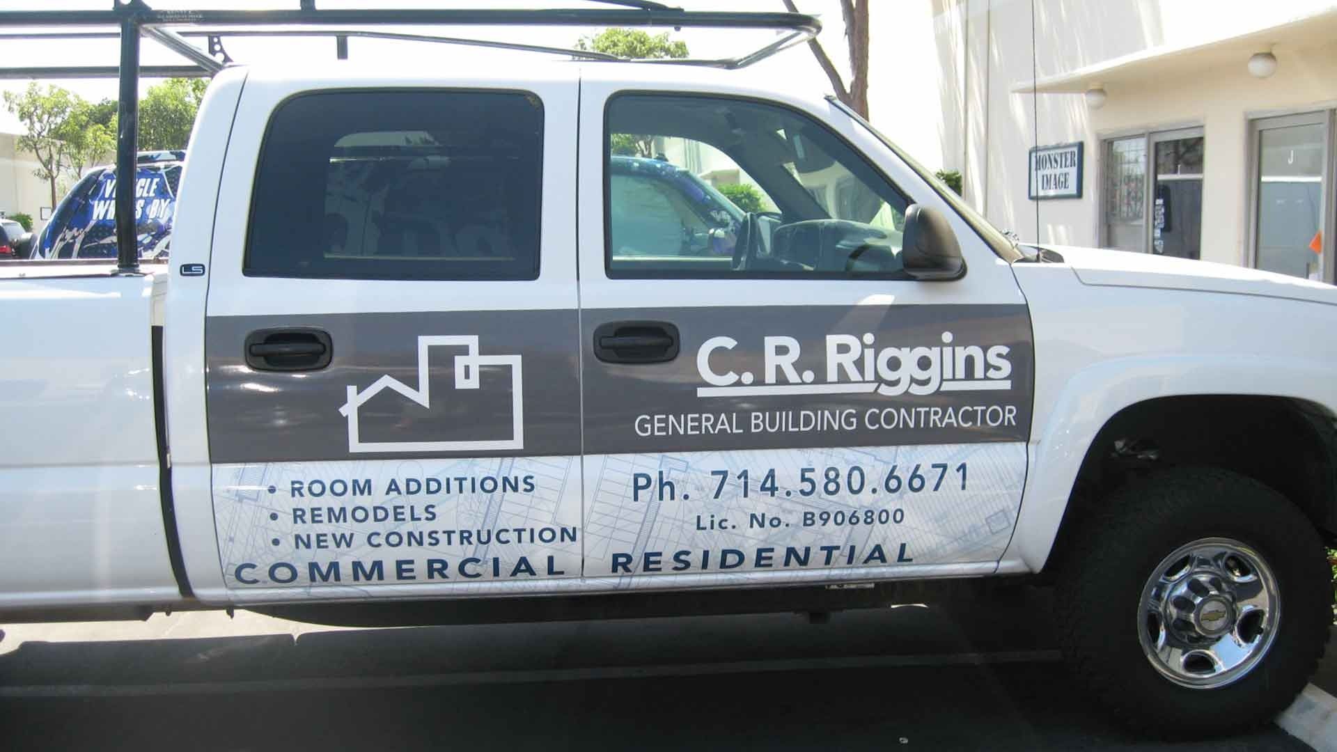 A white pickup truck with C.R. Riggins branding, contact information, and construction services listed on the door.