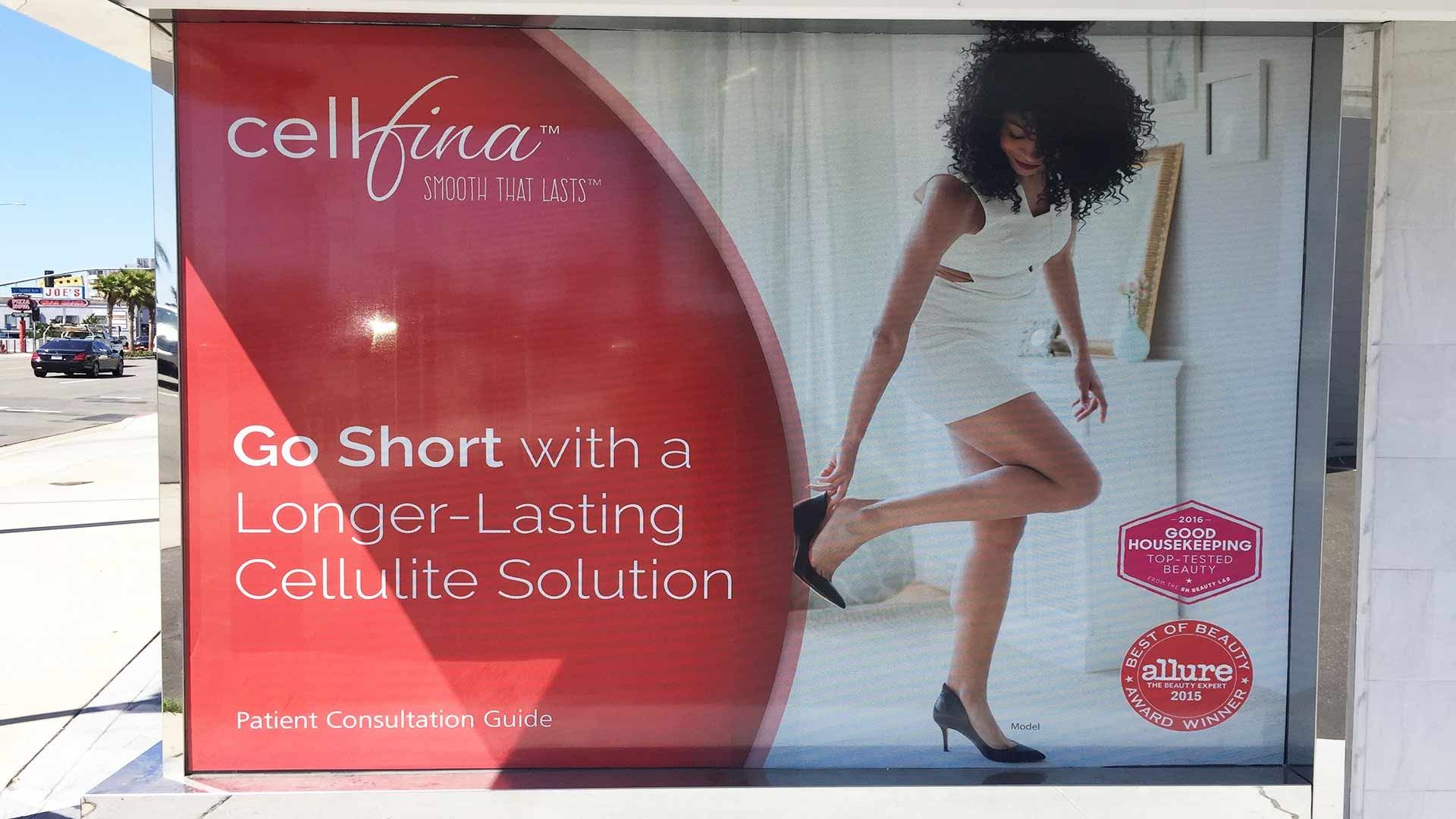 A Cellfina advertisement on a building, promoting a cellulite solution with text and a person in a white dress.