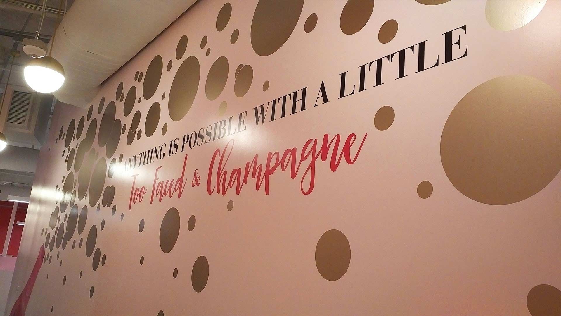 A pink wall featuring gold polka dots and the text 